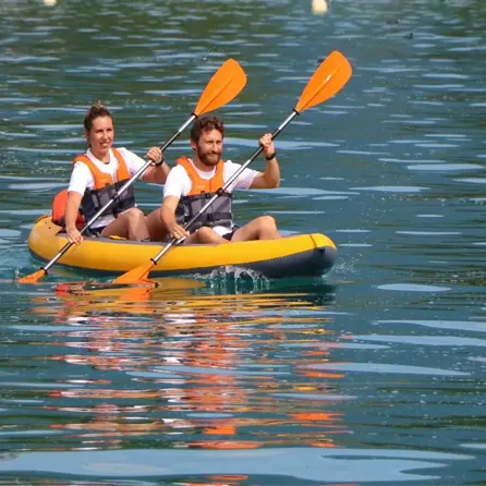 Deux personne dans un canoé sur un étang.