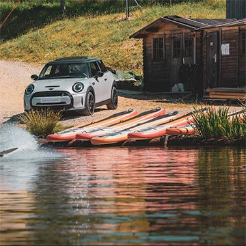 Paddle au bord d'un étang prêt d'une voiture Mini