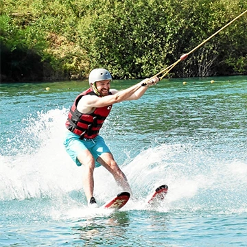 un homme en ski nautique lors d'un virage sur un wakepark