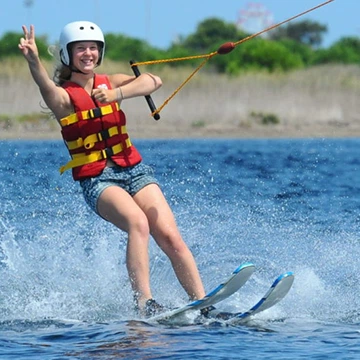 Fille en ski nautique avec une seule main.