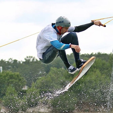 Un rider avec une planche sur le téléski nautique